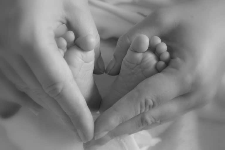 mains qui massent les pieds d'un bébé